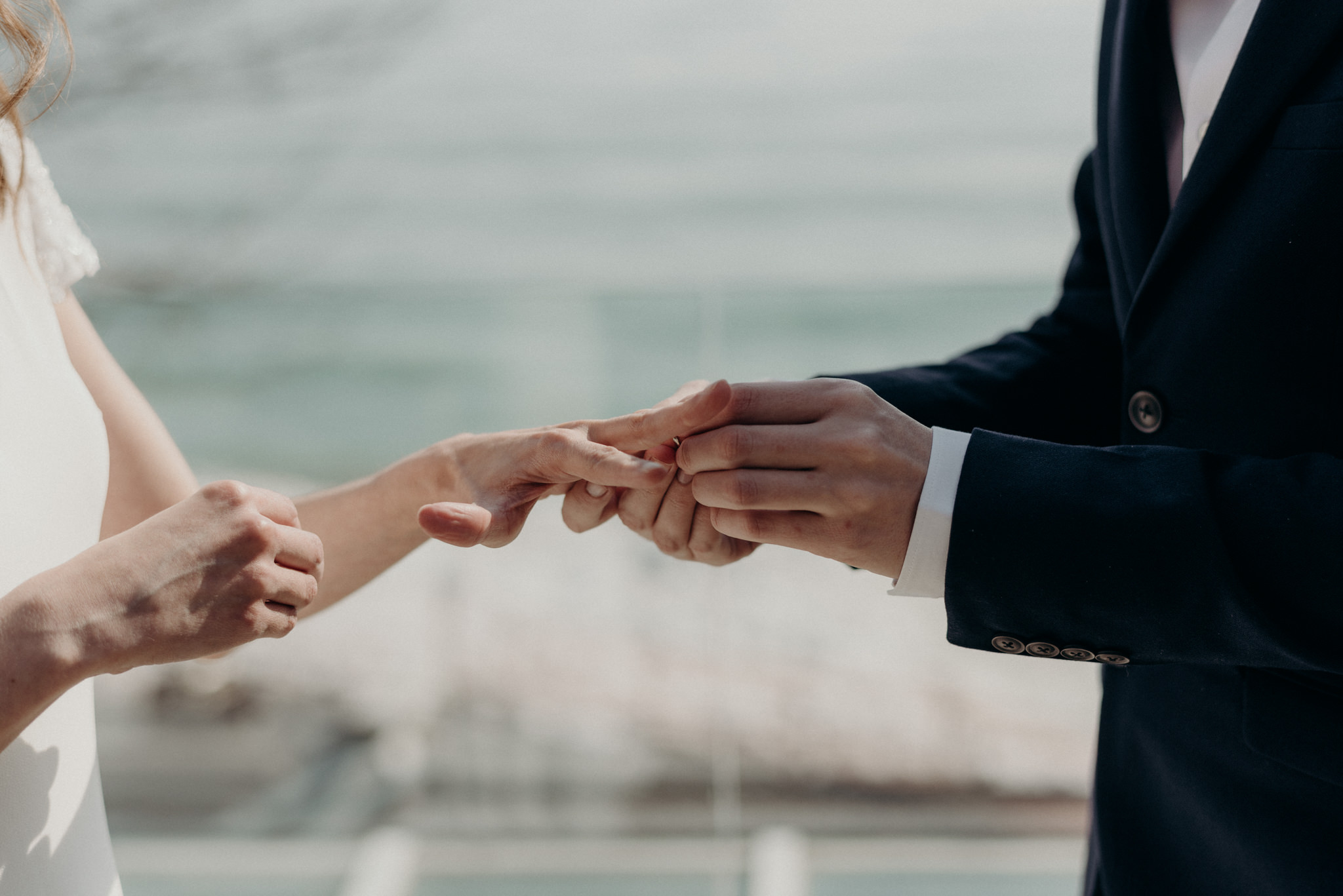 groom putting ring on brides finger