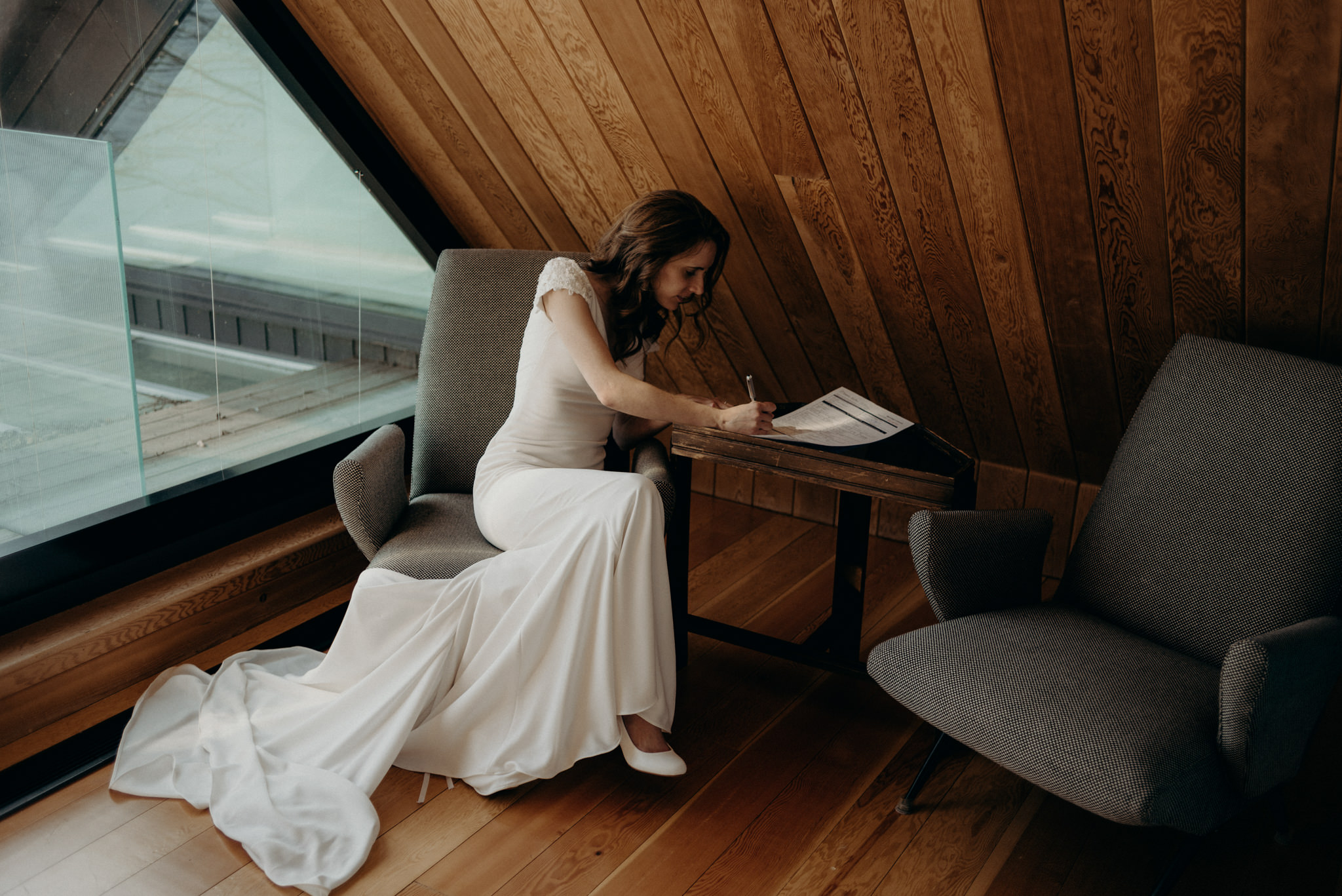 bride signing marriage license inside a-frame cabin