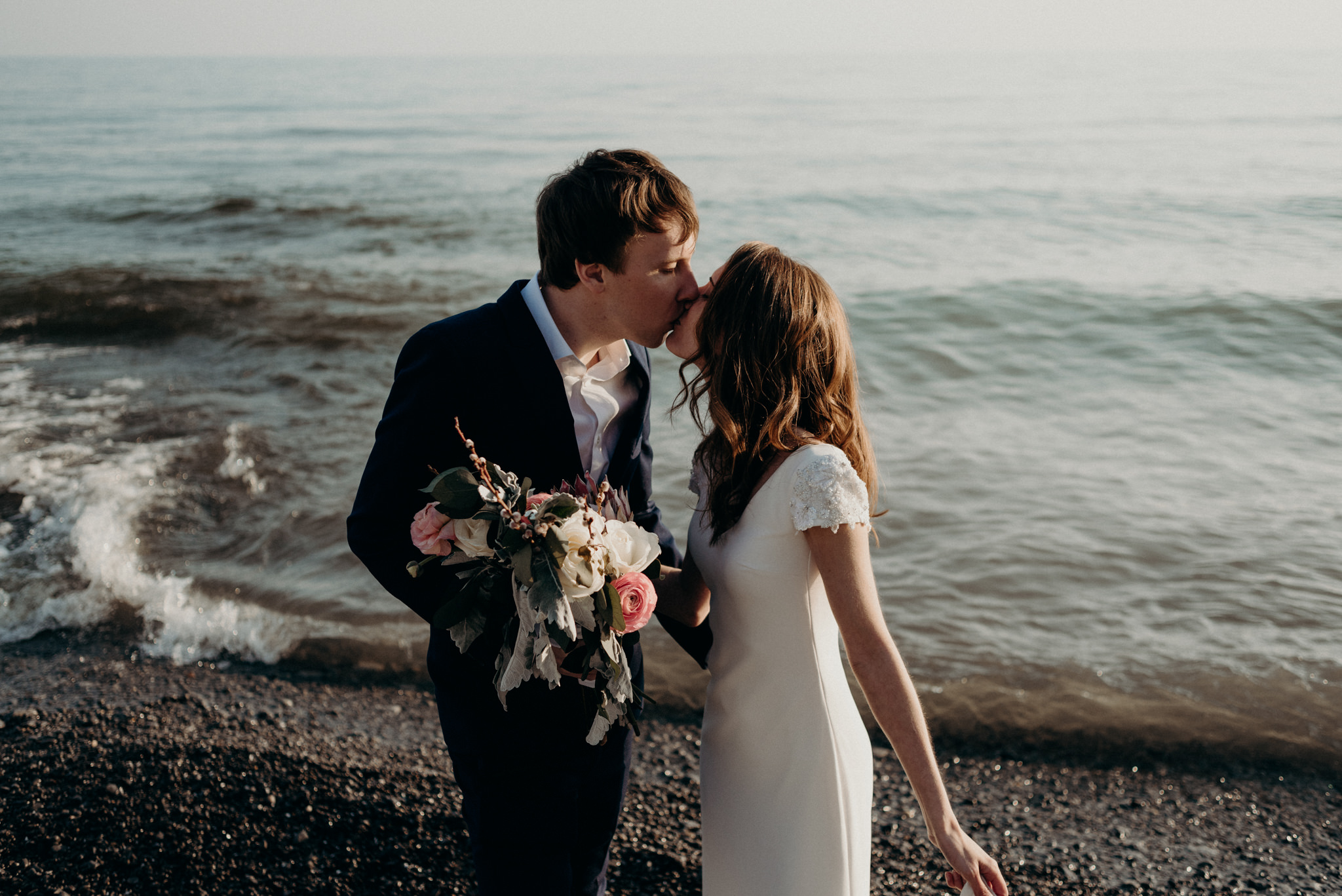 bride and groom kissing on the beach at Drake Devonshire