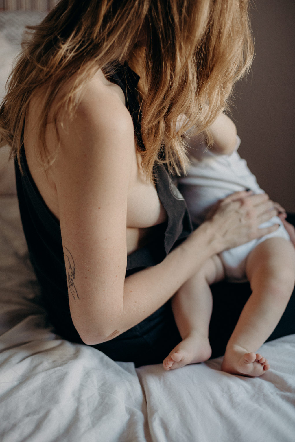 intimate in-home breastfeeding portraits on bed