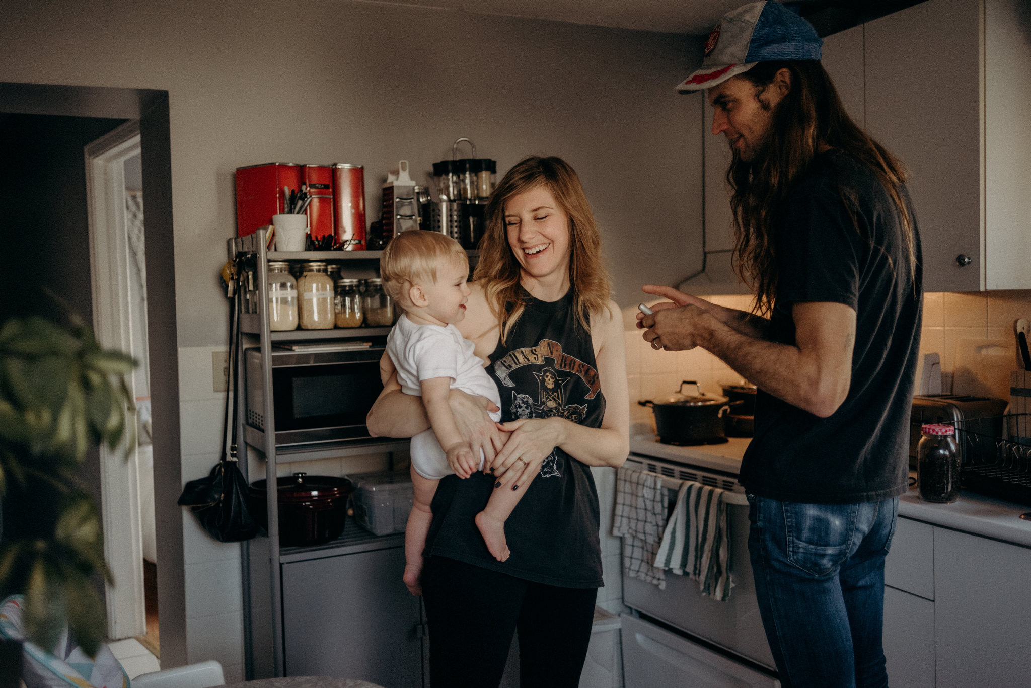 young couple with toddler in kitchen making coffee