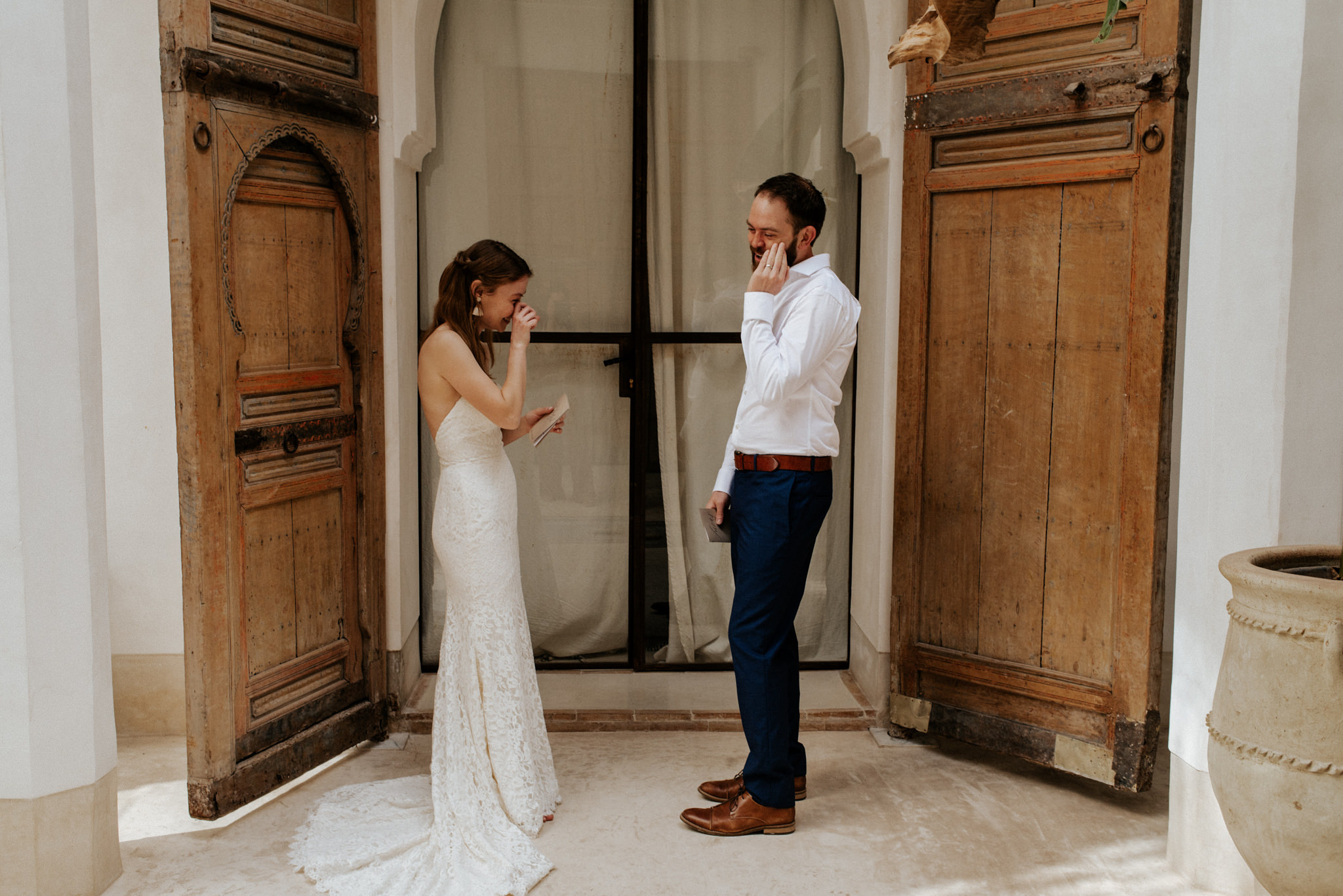 Emotional bride and groom wiping away tears after reciting vows