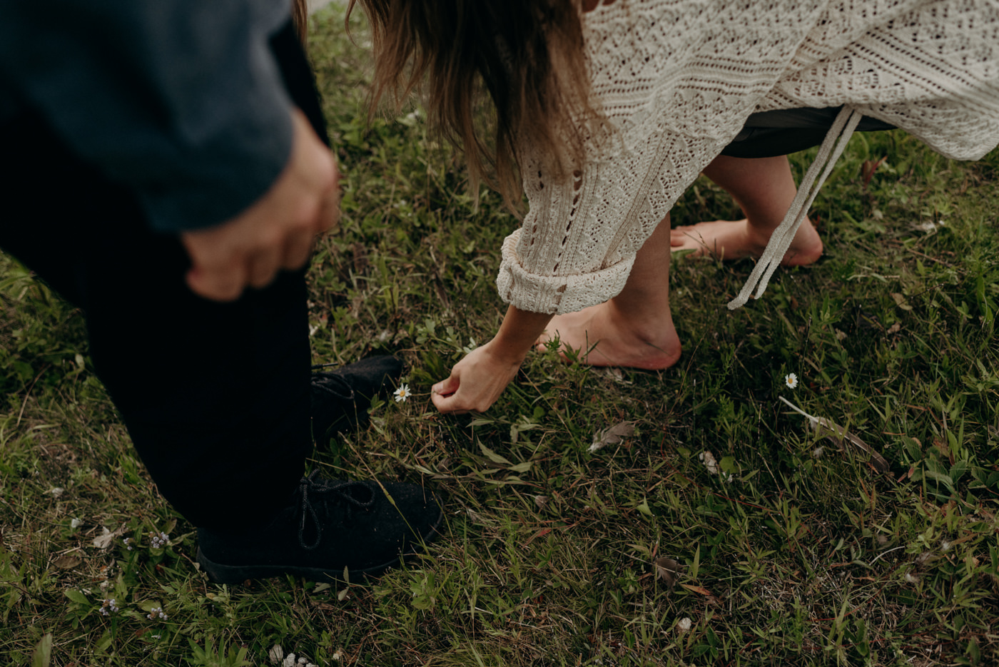 woman picking flowers in grass