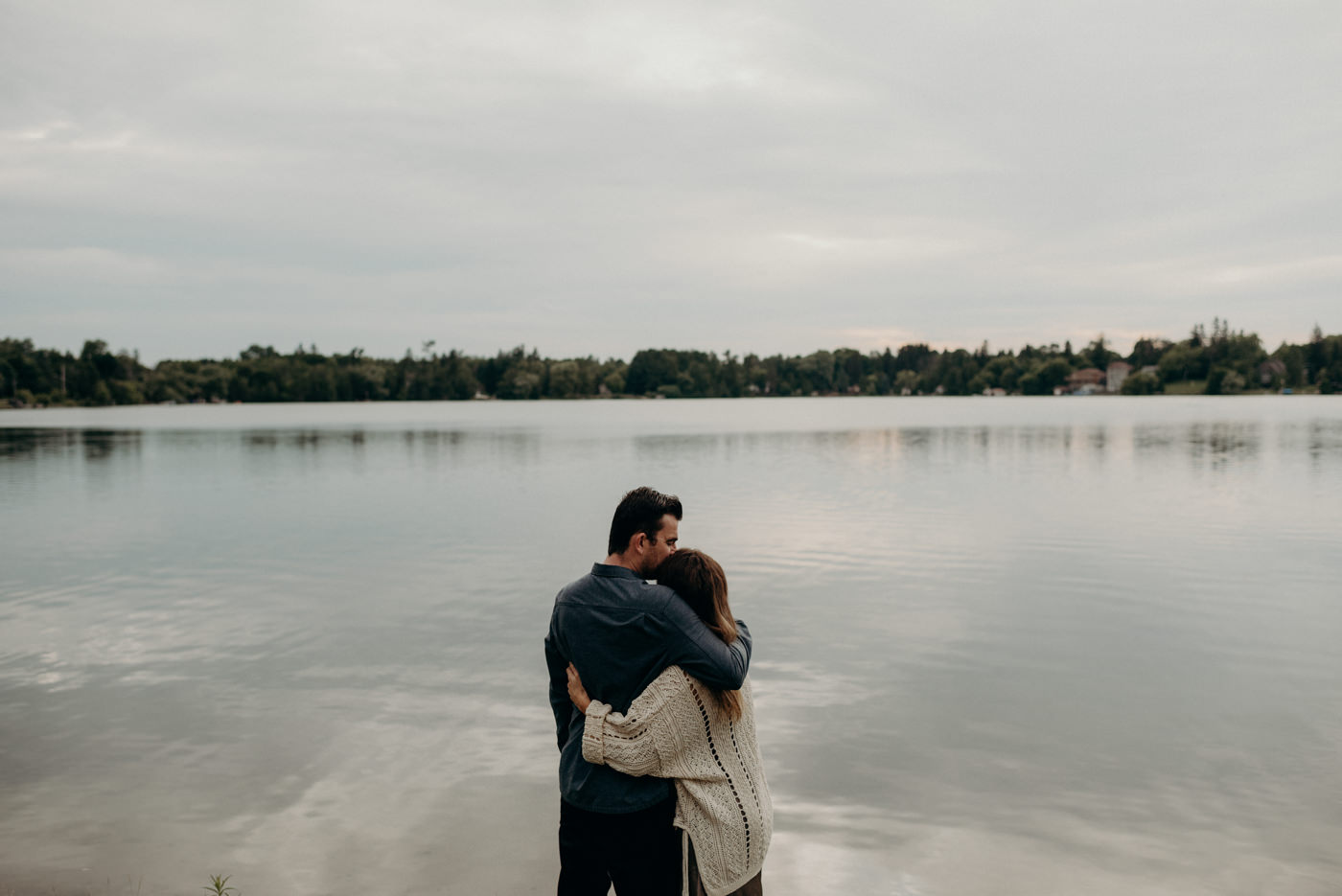 couple hugging by edge of lake