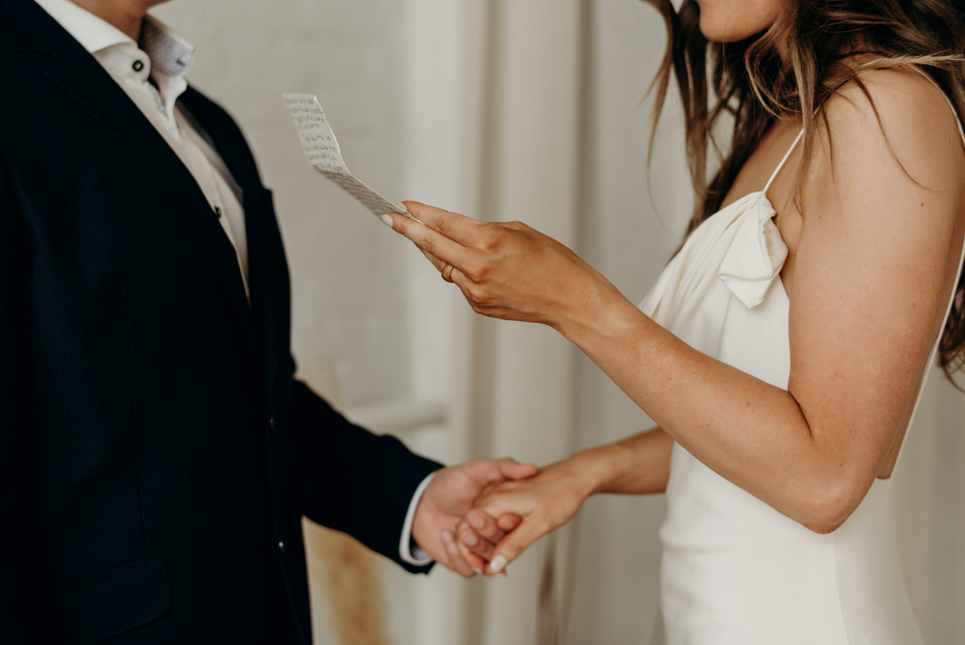 bride reads vows in cool midcentury loft elopement at Lovt Studio East in Toronto