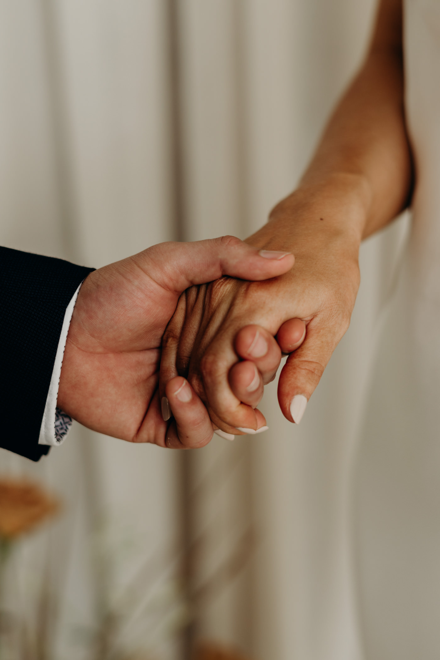 bride and groom holding hands during ceremony