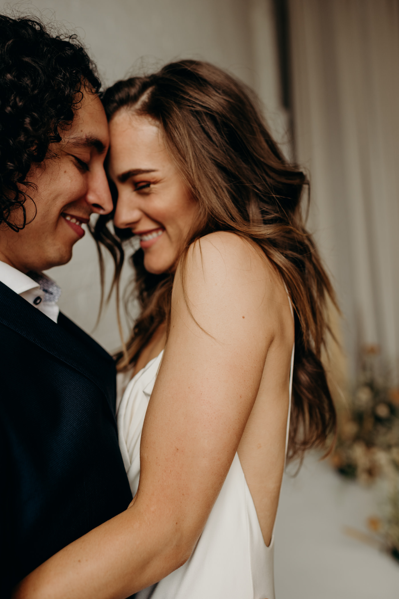 bride cuddling up to groom in loft studio