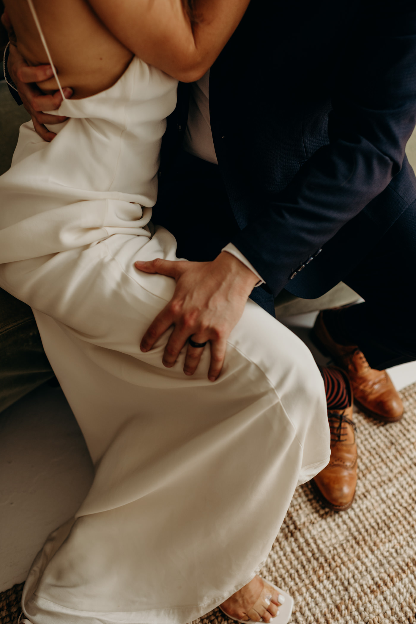 groom hand on brides leg as they kiss