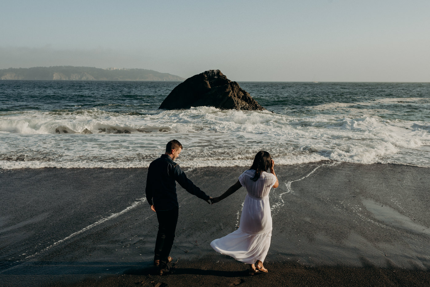 Couple holding hands and walking on beach