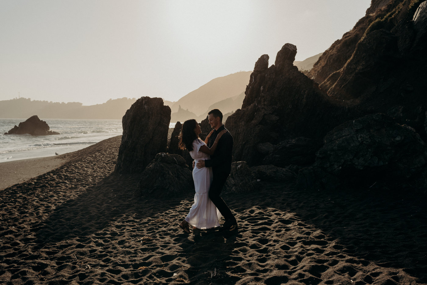 Dancing in the setting sun light on the beach during this Marin Headlands engagement shoot