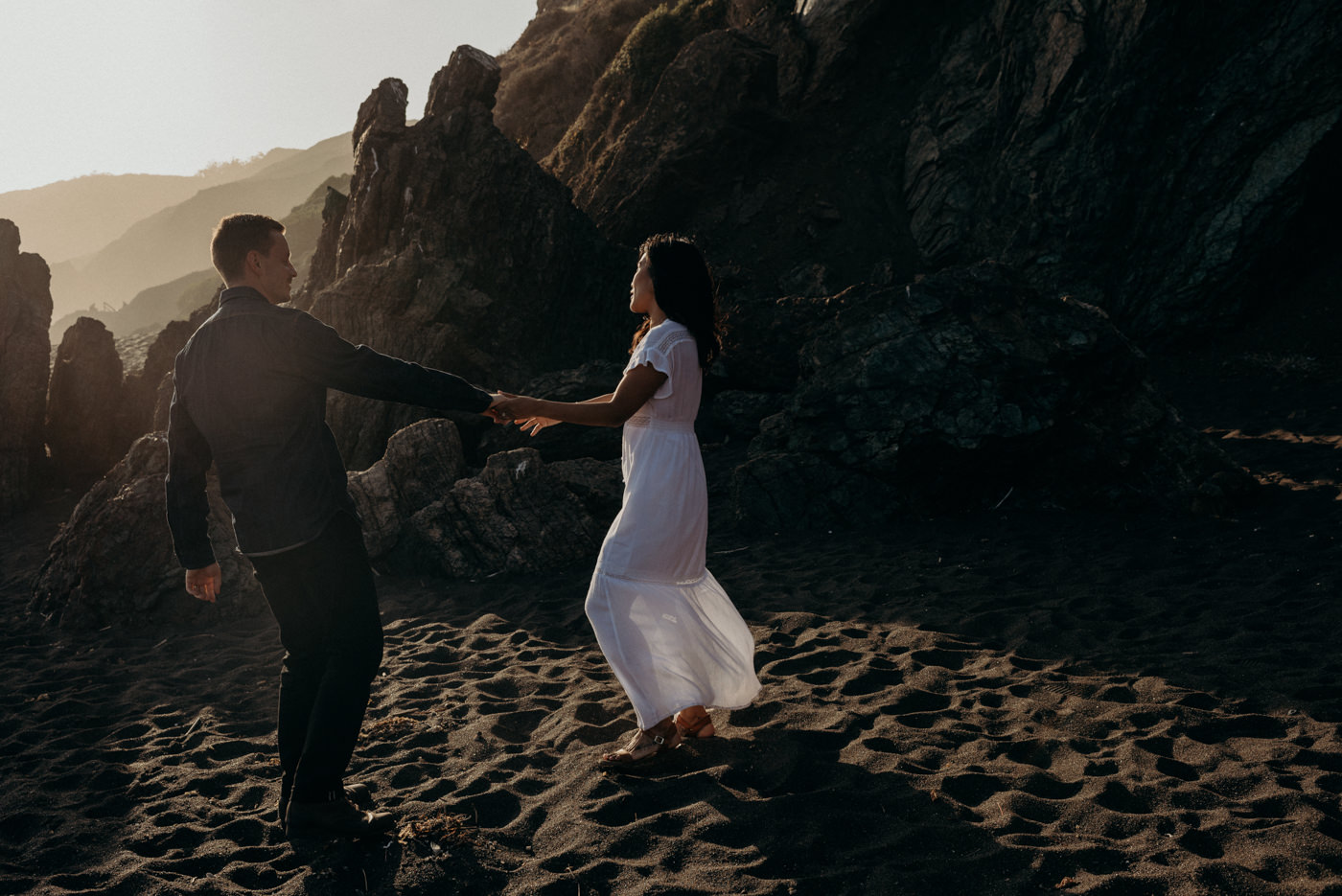 Dancing in the setting sun light on the beach during this Marin Headlands couple shoot