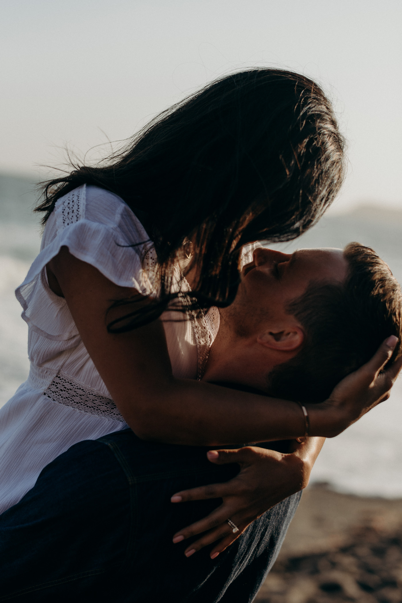 Couple standing on rocks at sunset