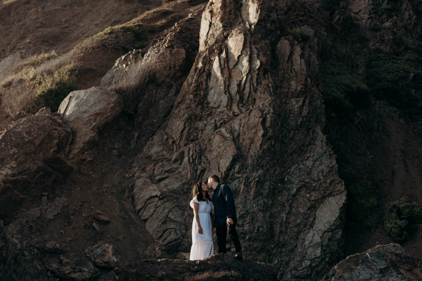 Couple standing on beach hugging at sunset