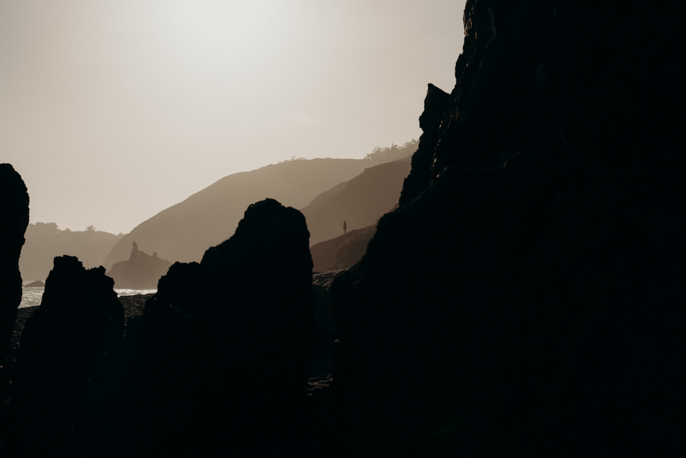 Couple walking on beach at sunset at Marin Headlands