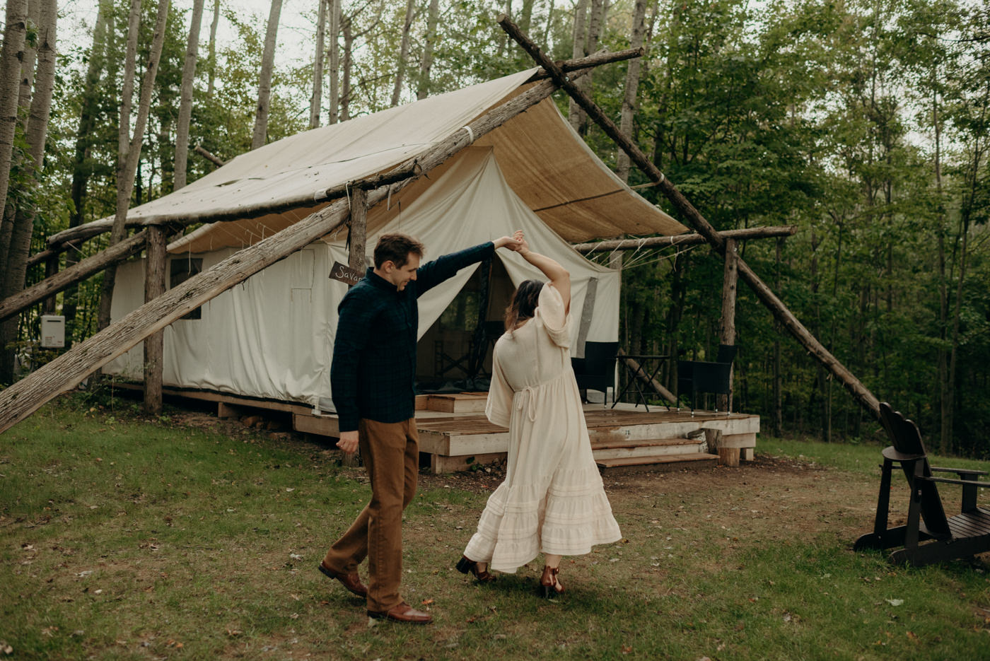 Couple dancing in front of glamping tent