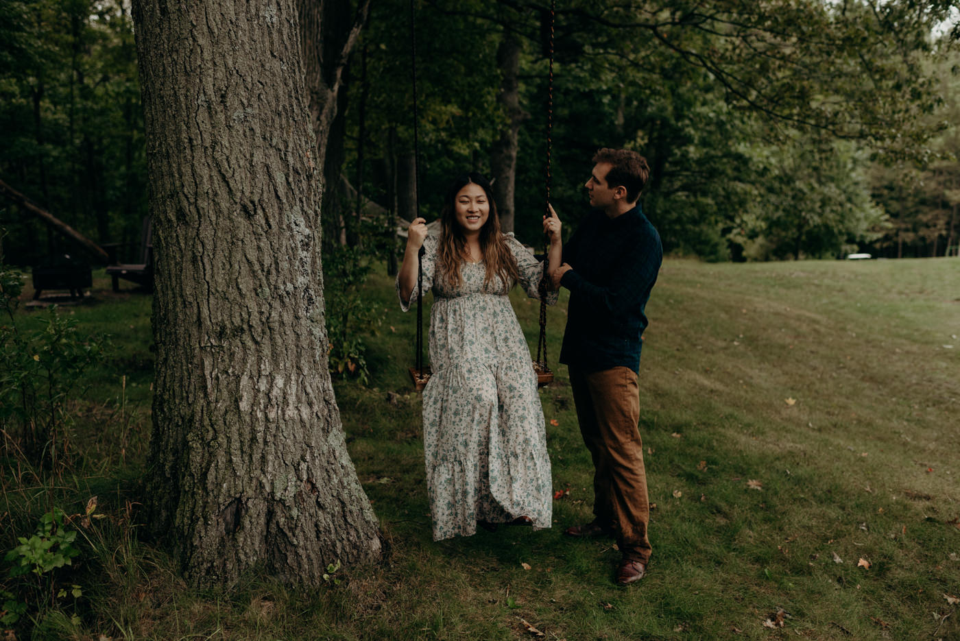 guy pushing girl on tree swing