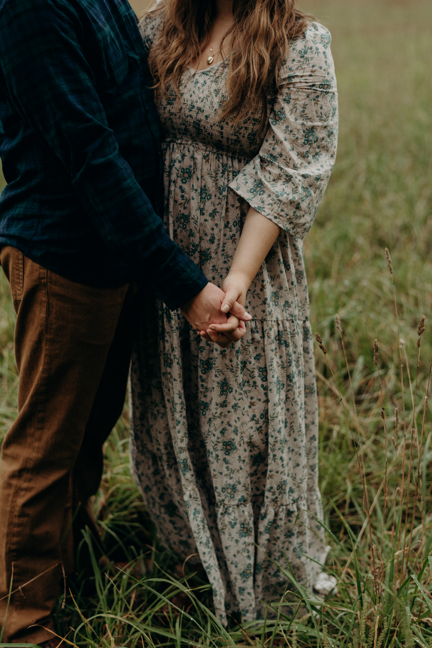 holding hands in a field for engagement shoot