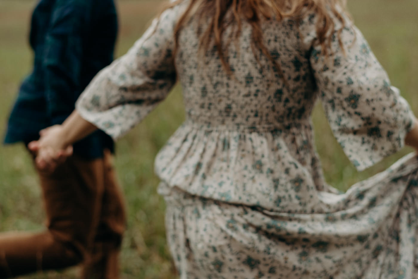 couple running through a field at Whispering Springs