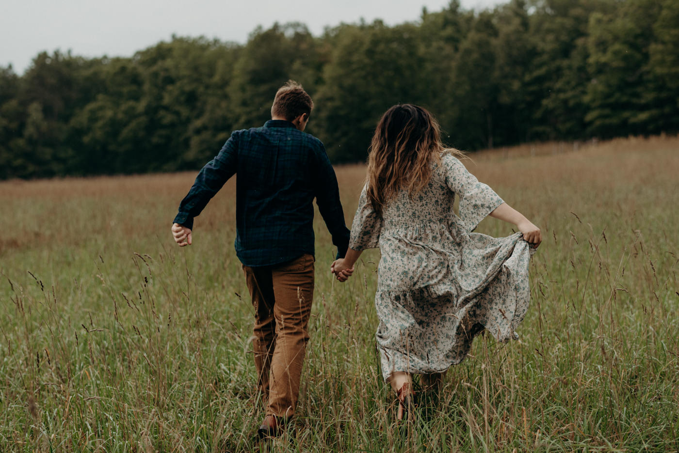 couple running through a field at Whispering Springs