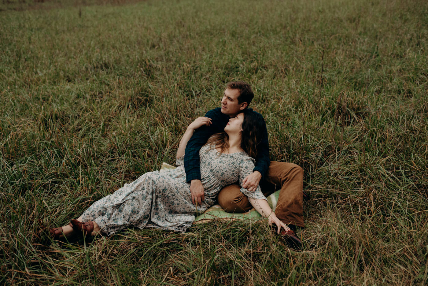 Couple lying in a field during their dreamy Whispering Springs engagement session