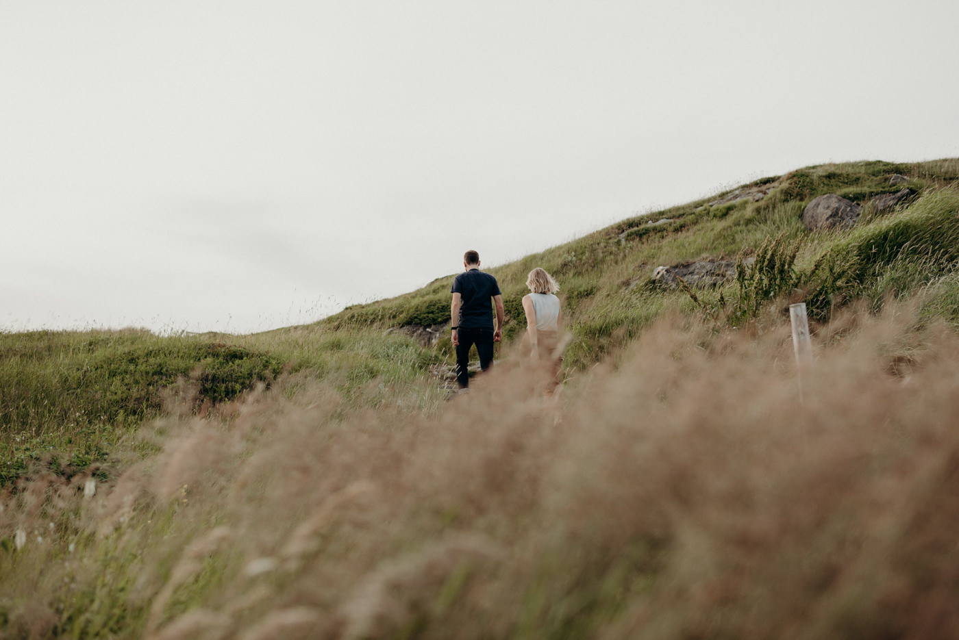 Couple walking in grassy trail to artist residence on Fogo Island