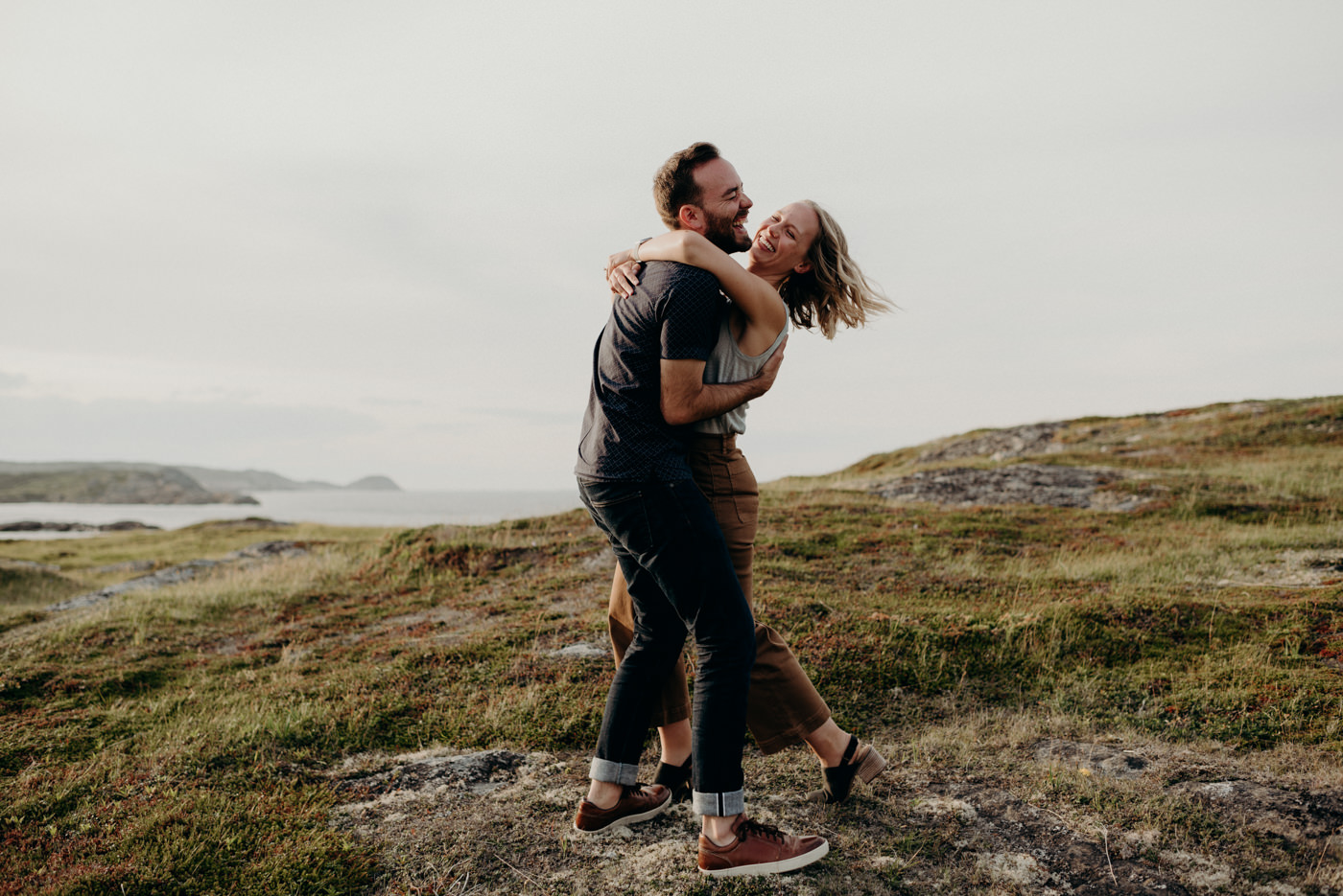 Couple hugging and laughing by the ocean, Fogo island couple shoot