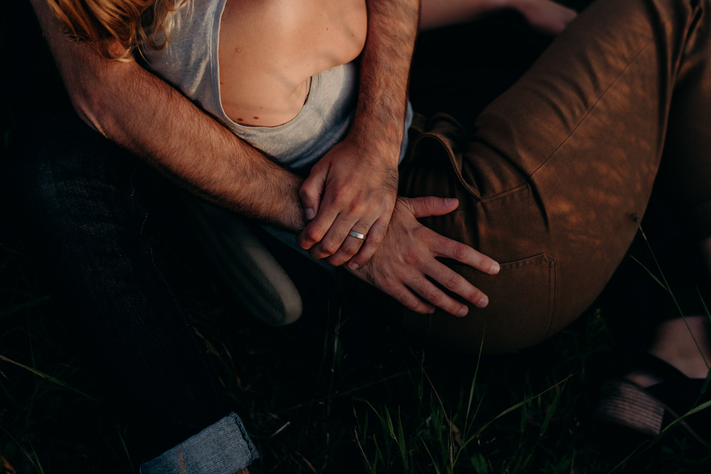 couple sitting in grass at sunset