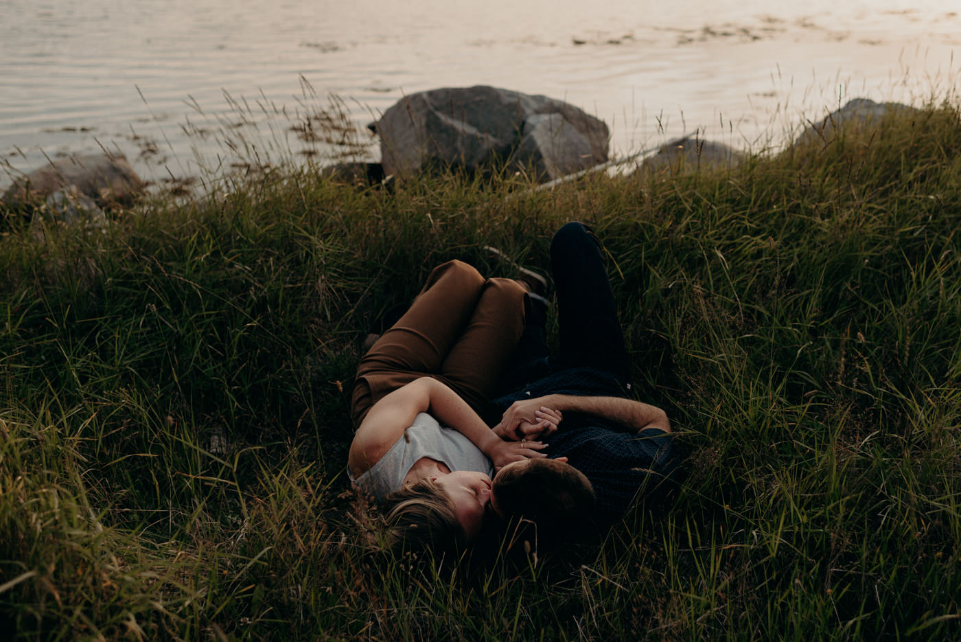 Couple lying in grass at sunset in Tilting, Fogo Island