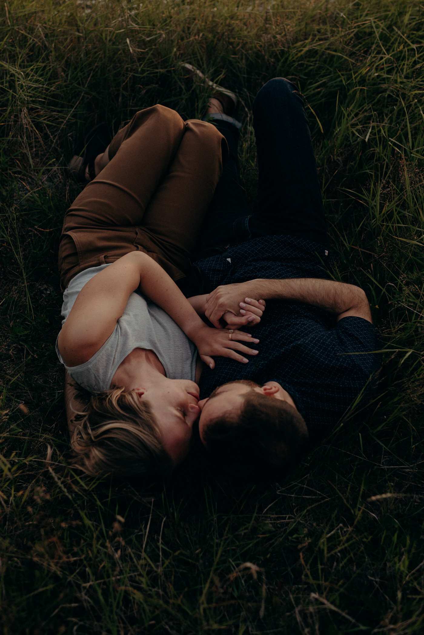 Couple lying in grass at sunset in Tilting, Fogo Island