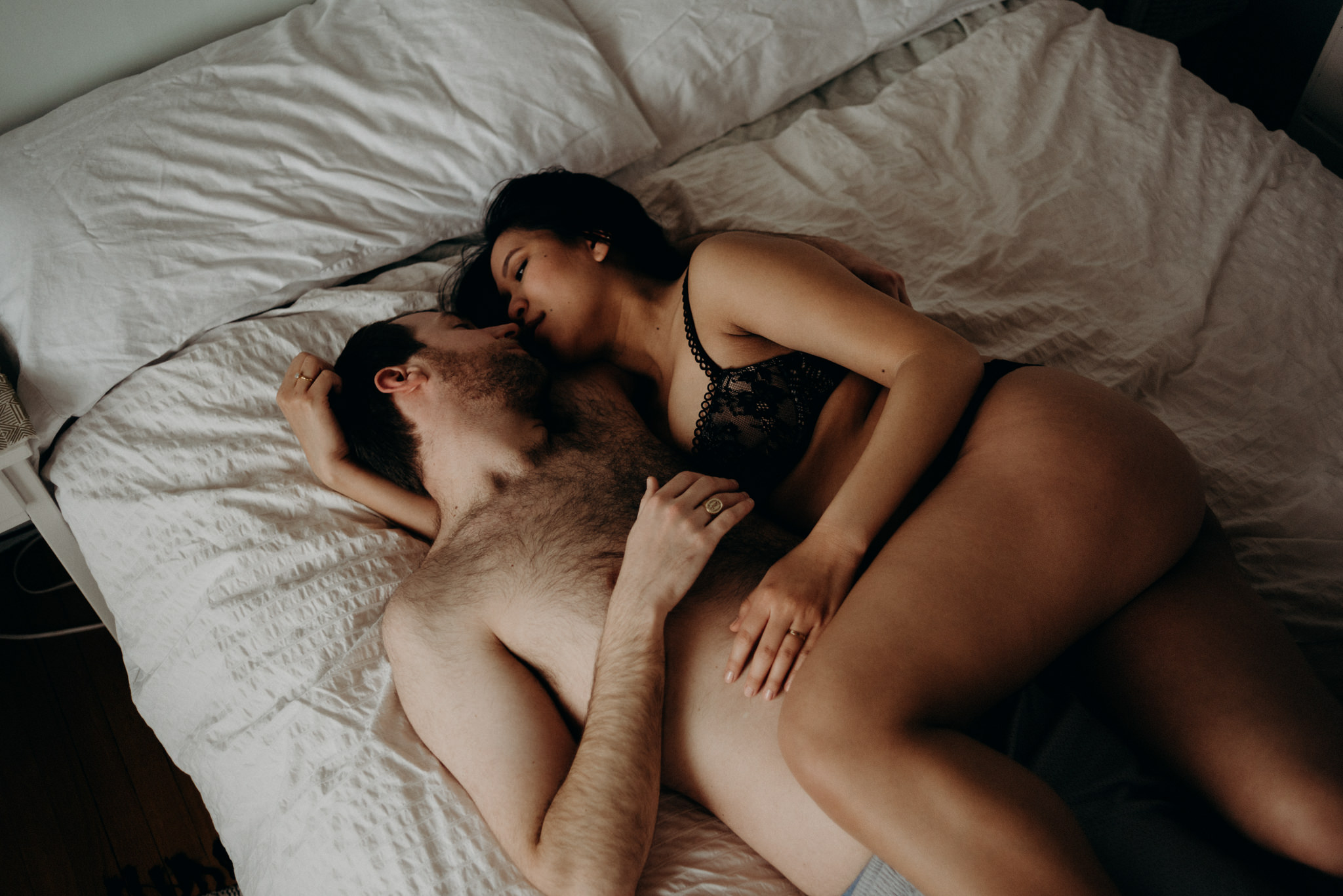 sexy couple portraits on bed for their maternity shoot