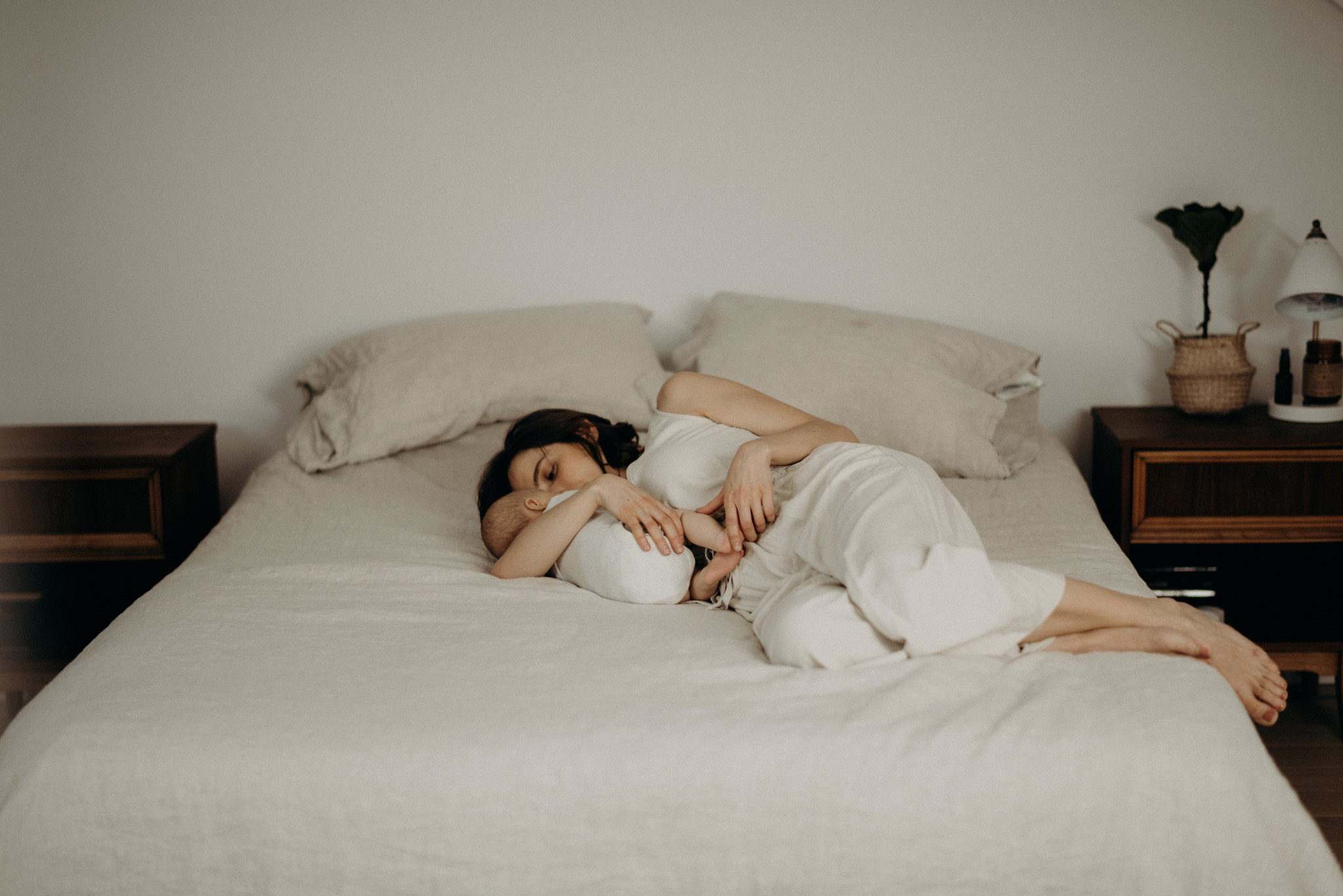 mother and son lying down in bed cuddling