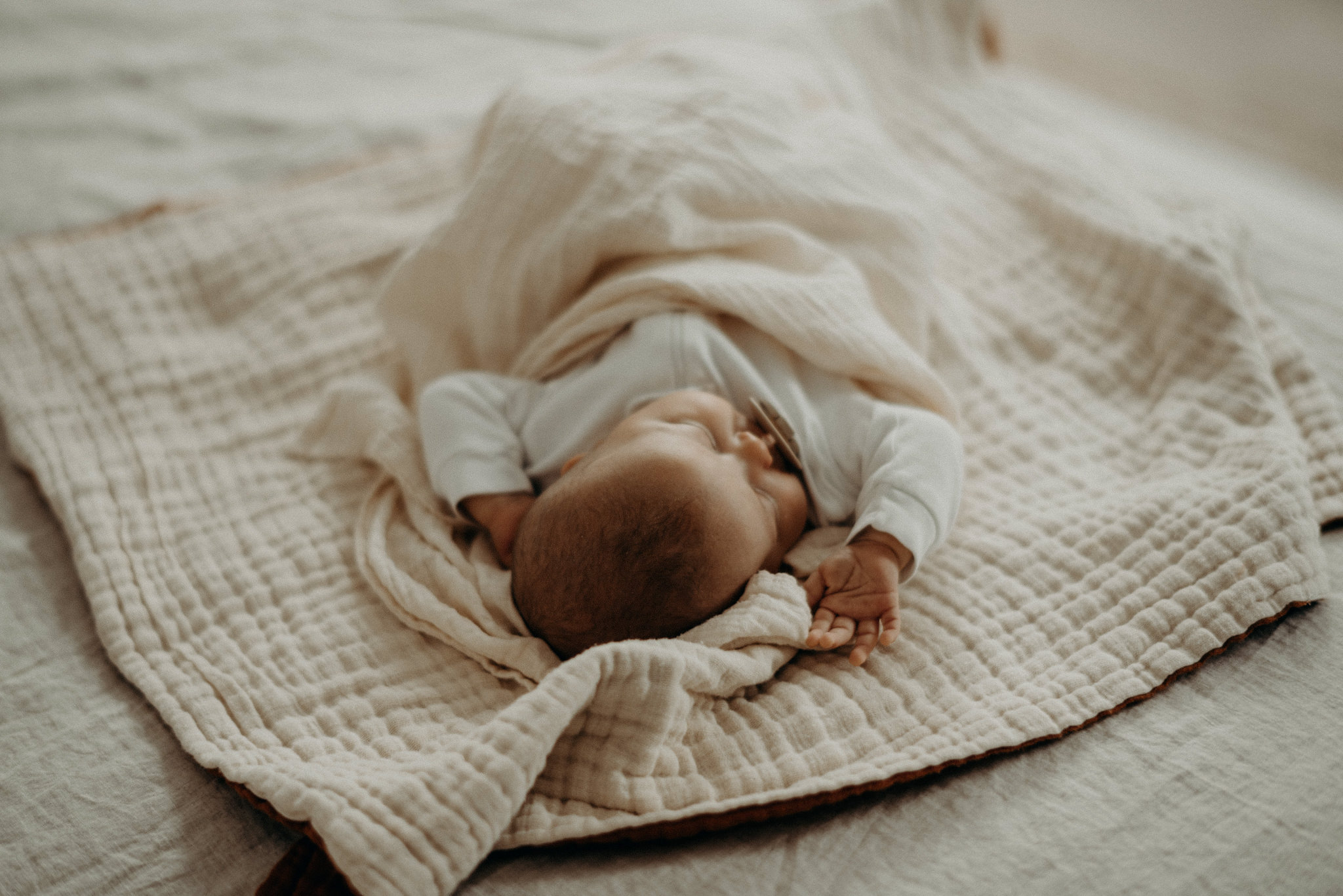 baby sleeping in neutral bedding