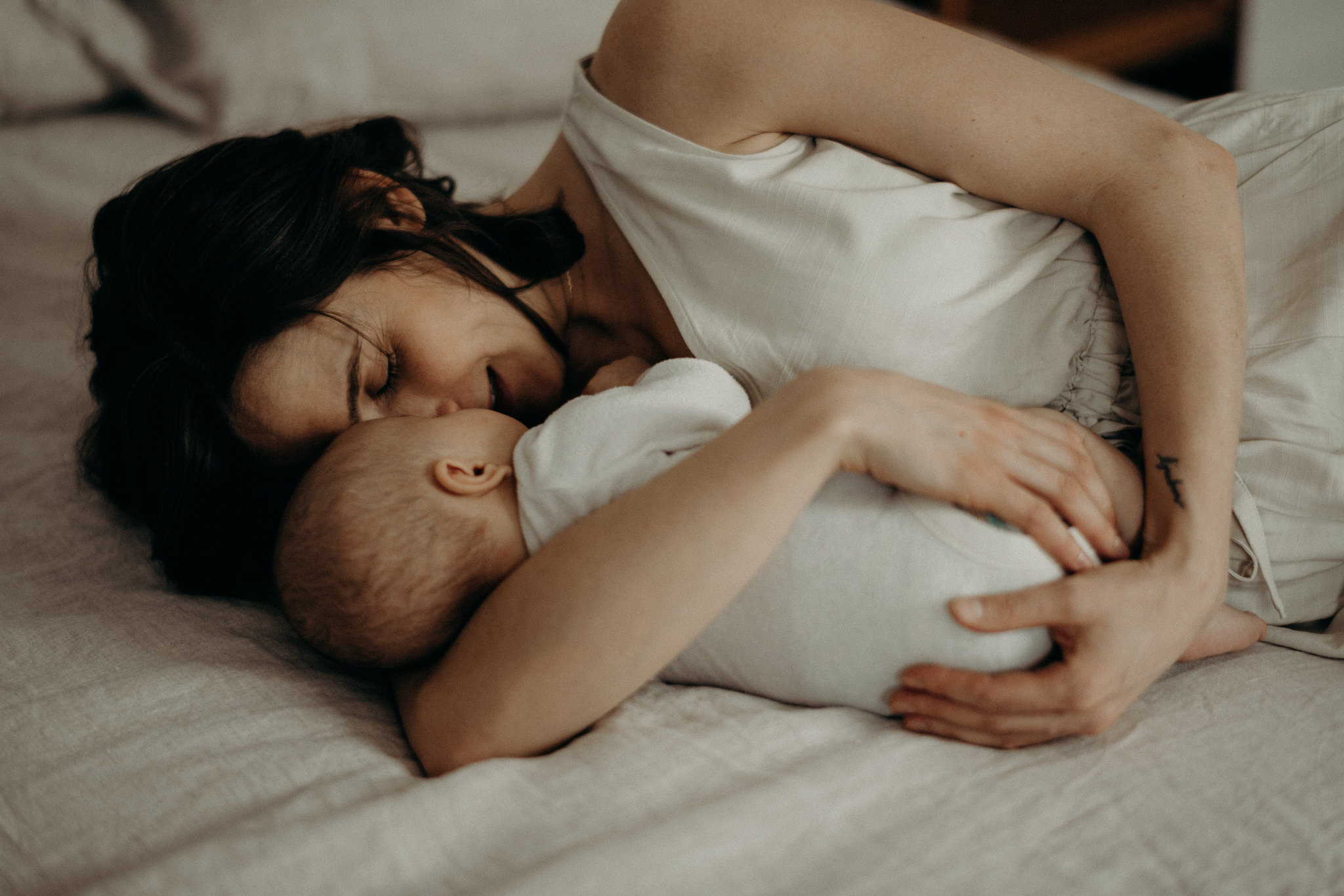 mother cuddling her infant son in bed