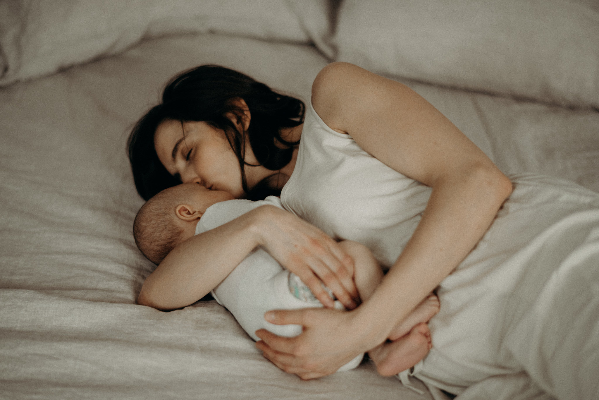 mother cuddling her infant son in bed