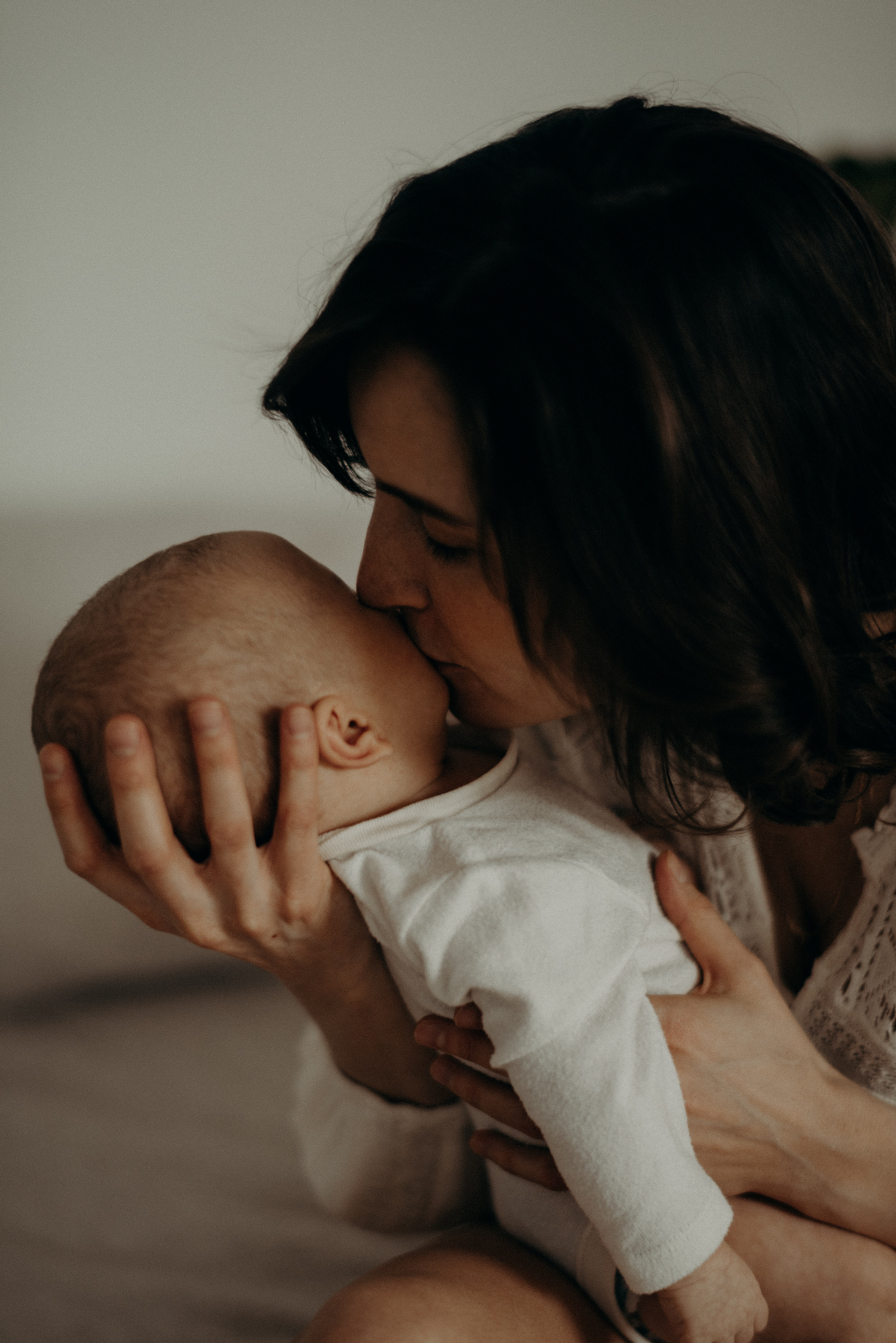 mother kissing her newborn baby on the cheek