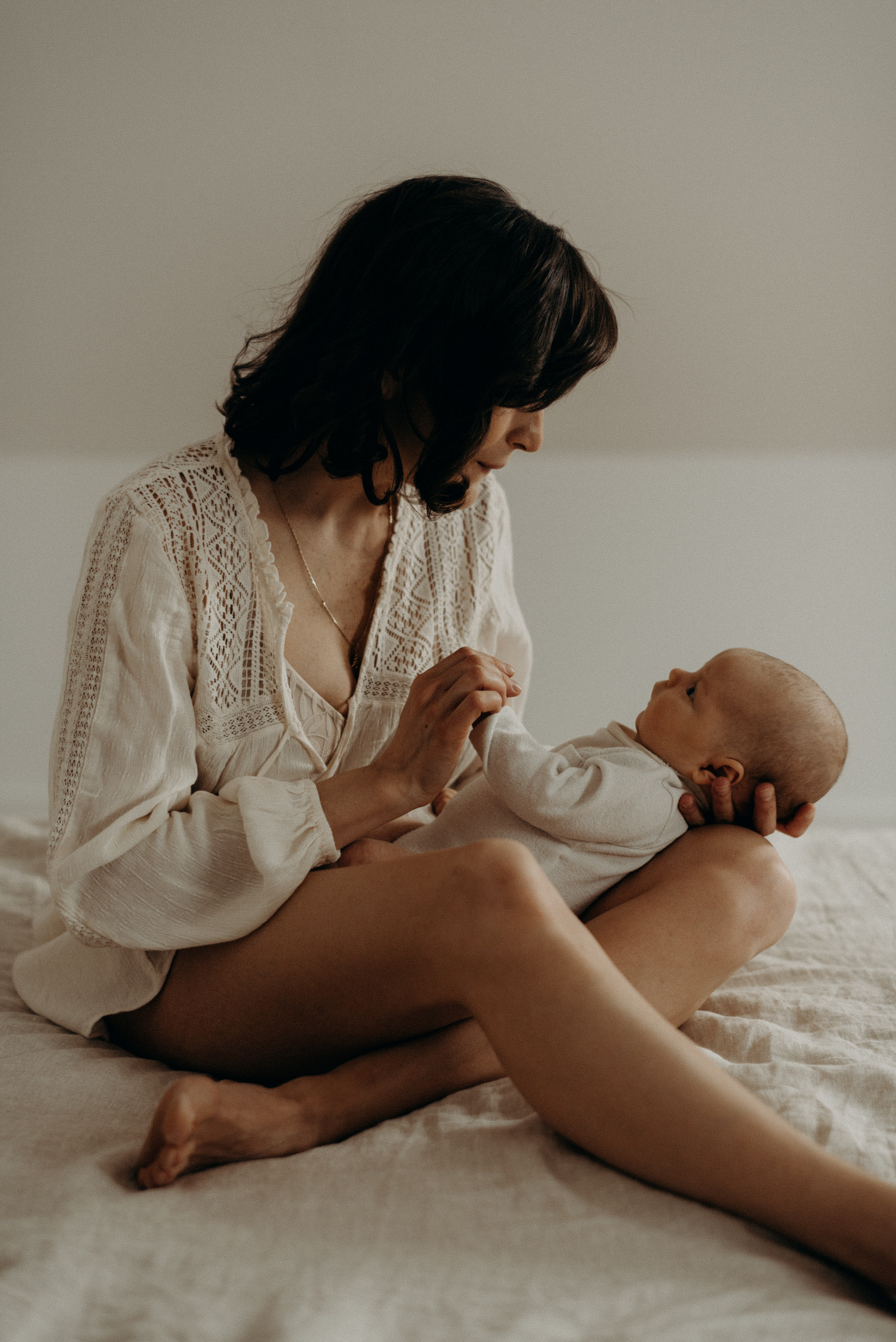 mother holding newborn baby on the bed