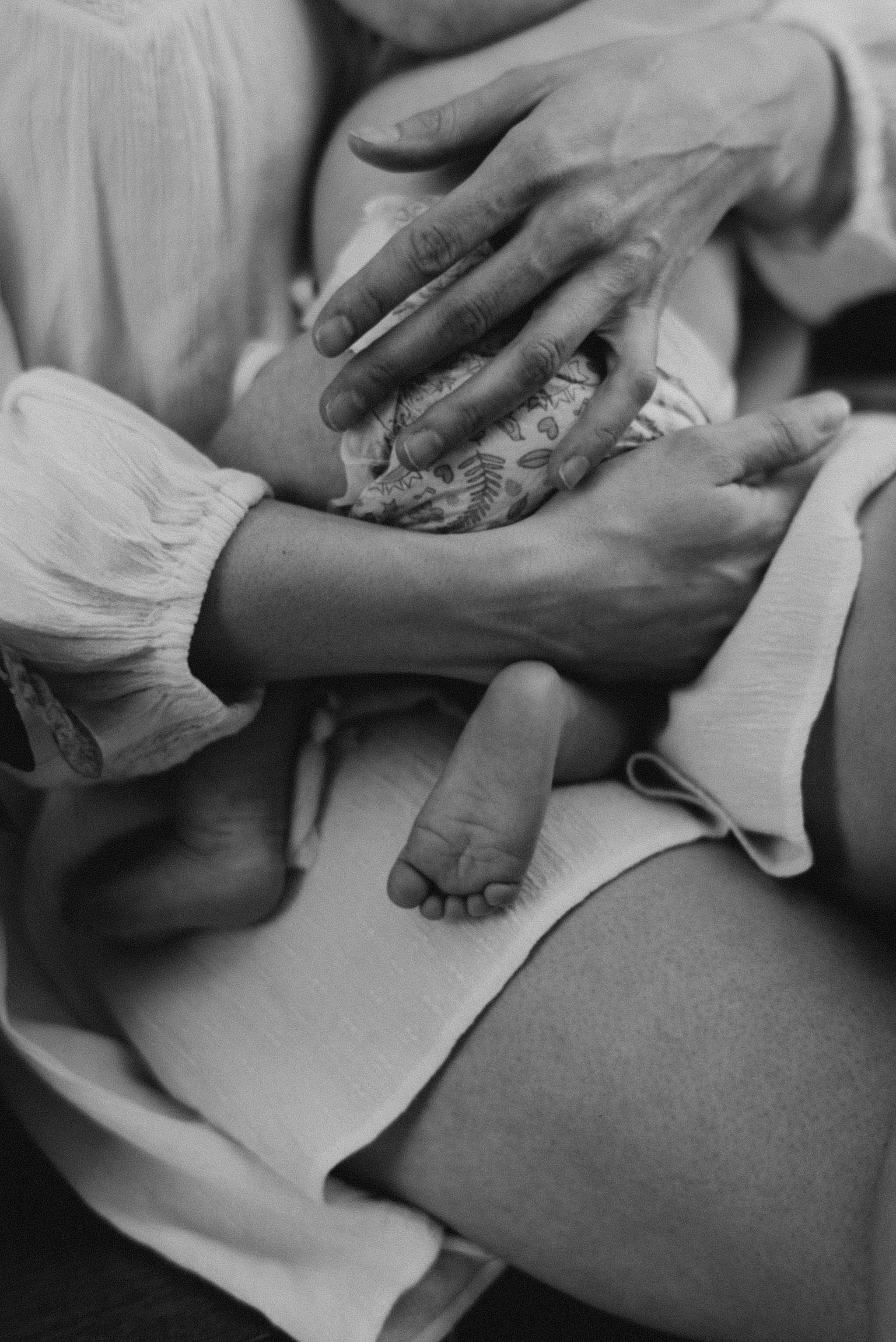 mothers hands on newborn baby's back