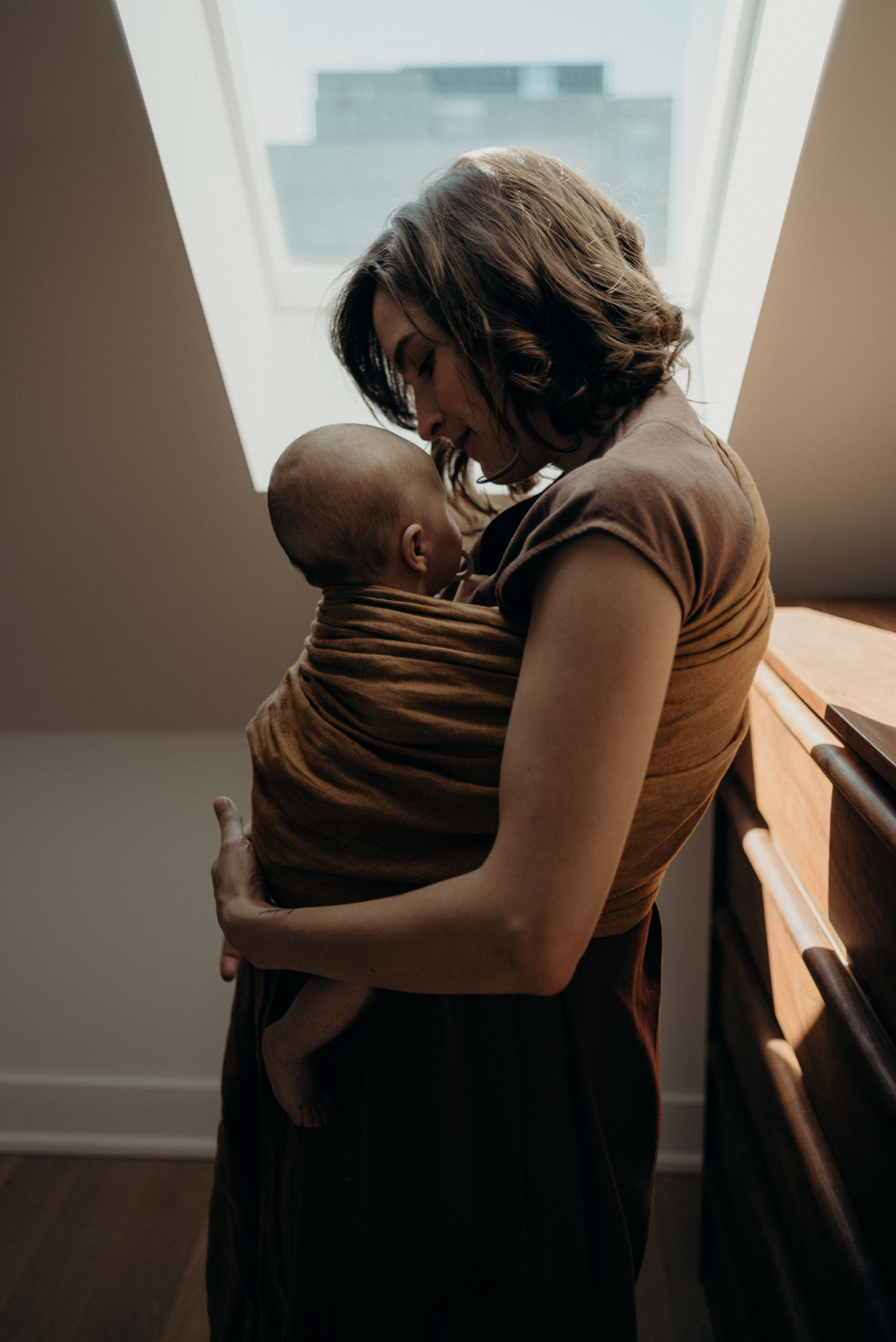 mother holding baby in sling