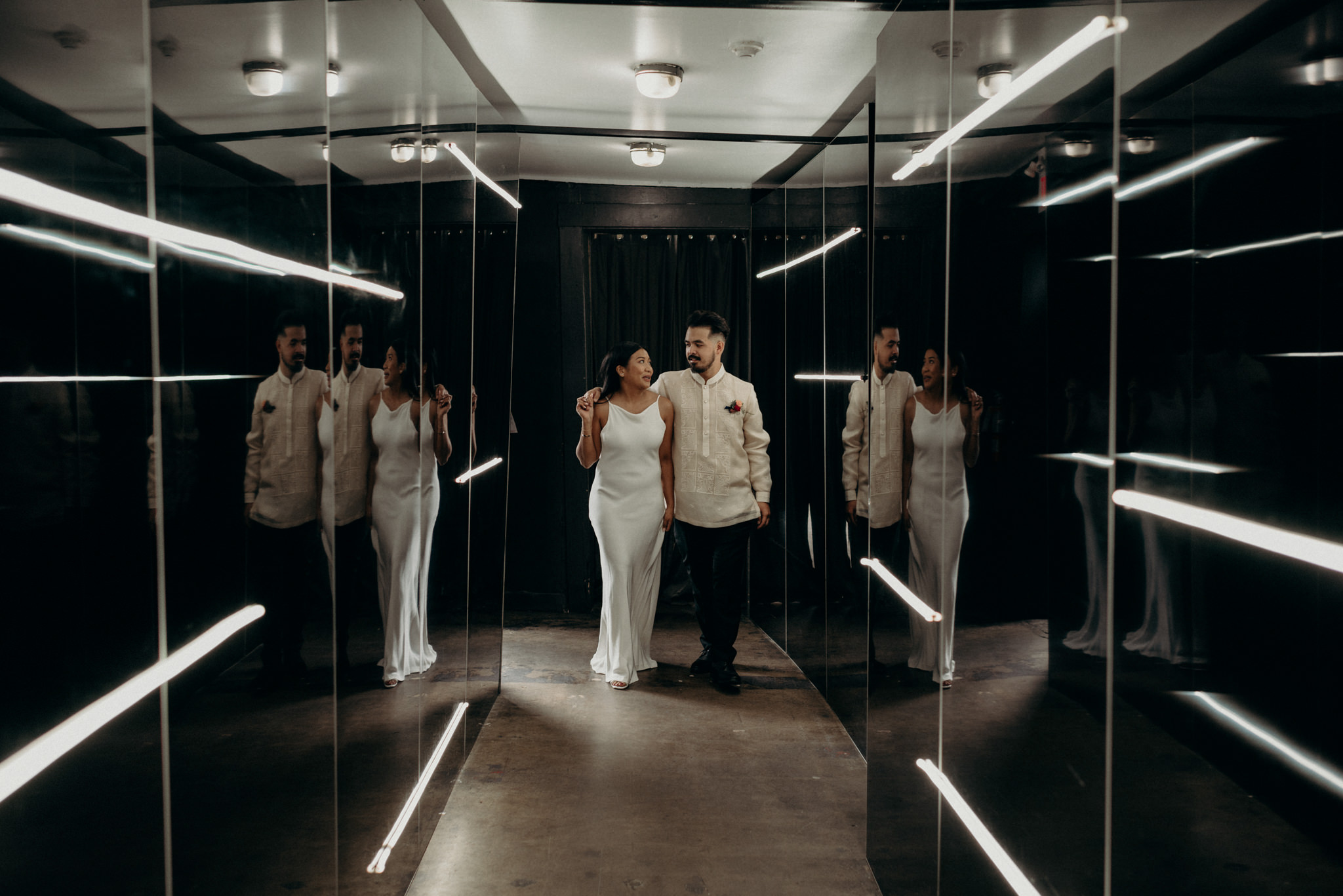 Bride and groom portraits walking down lit hallway at Airship37