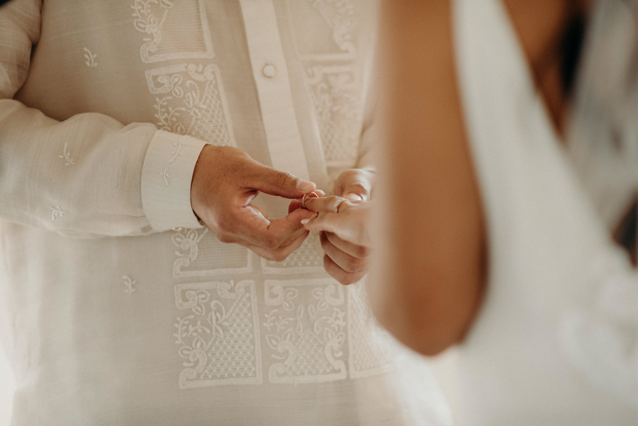 groom putting ring on bride's finger