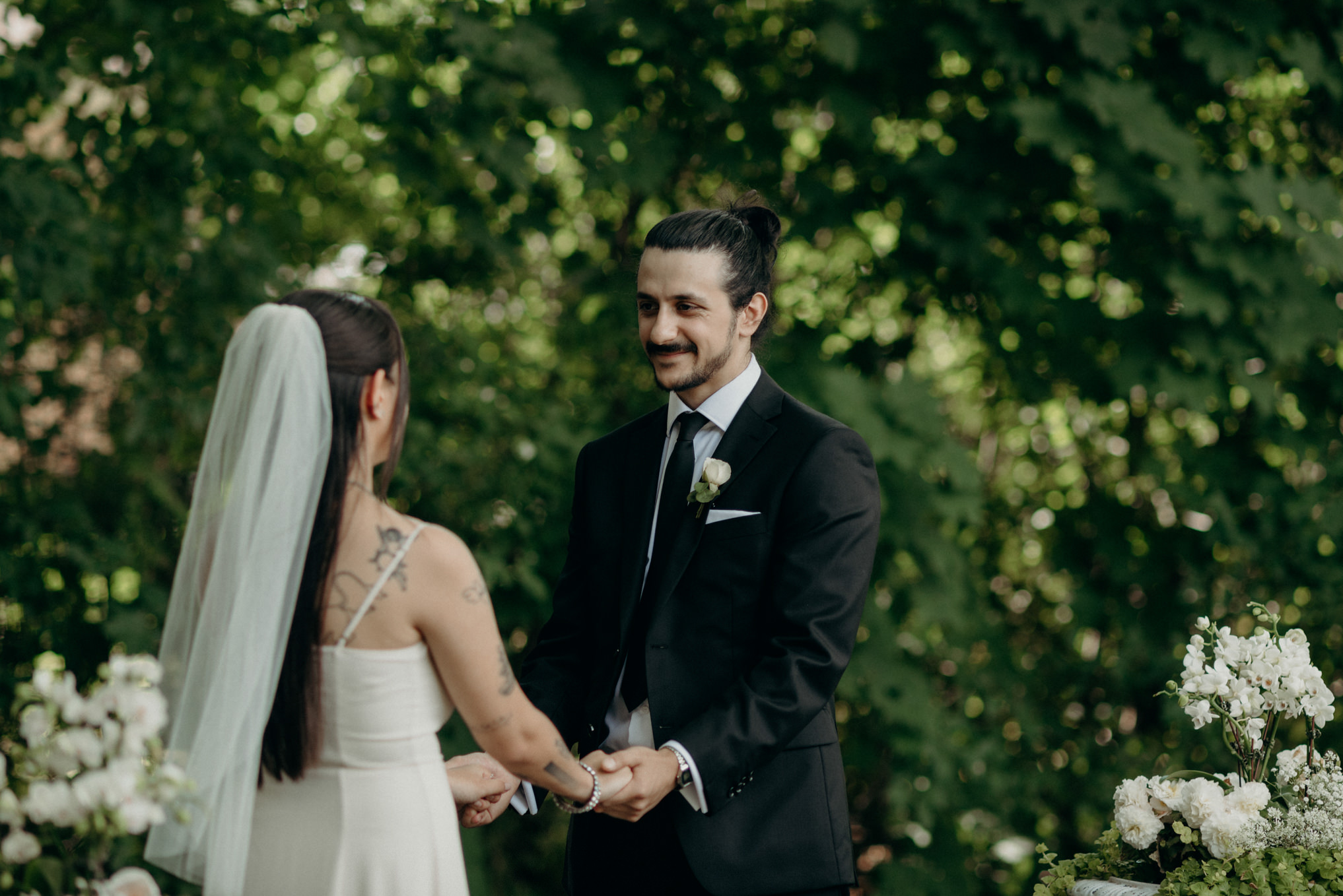 Groom smiling at bride during backyard wedding ceremony