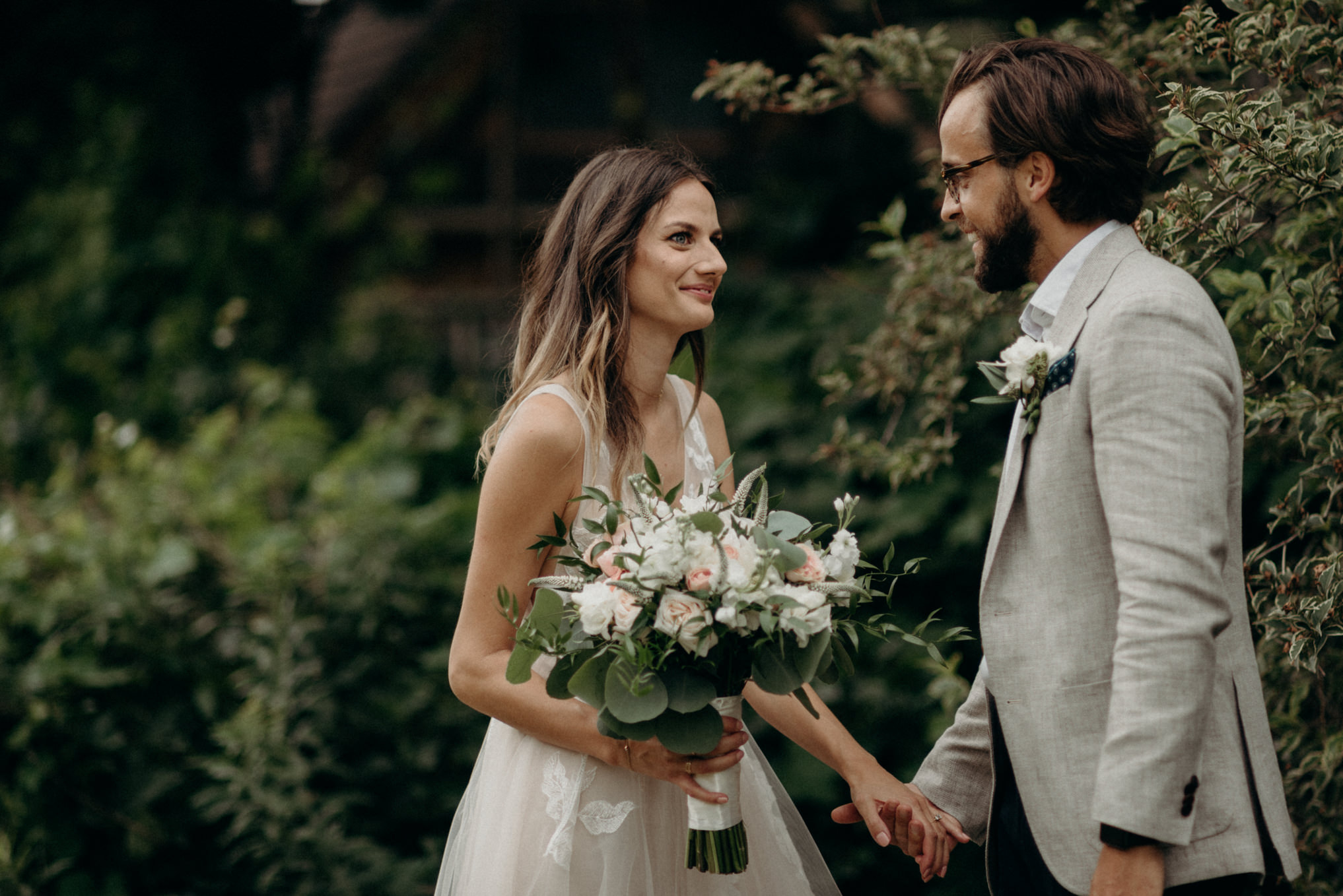 bride and groom holding hands in backyard