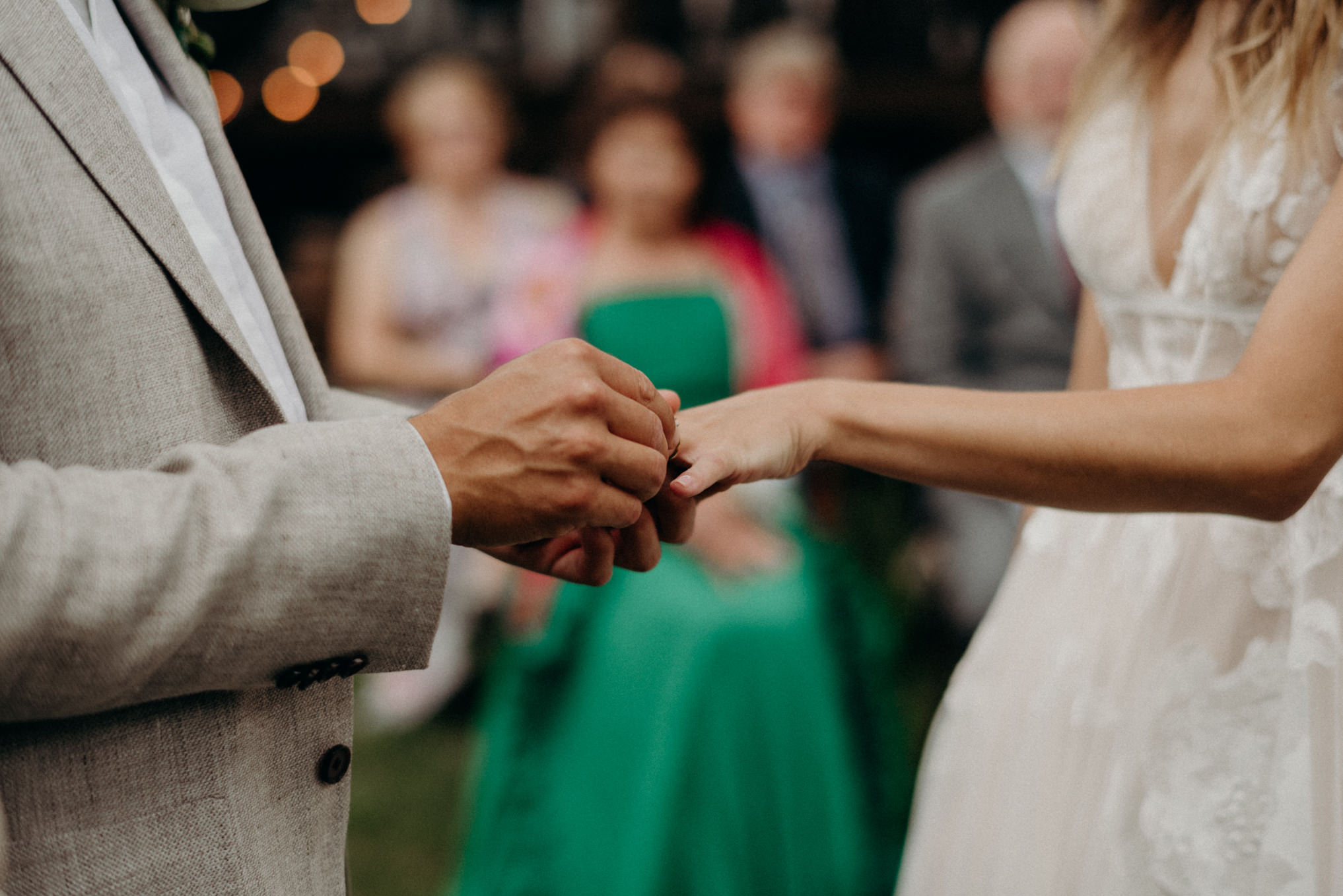 groom putting ring on bride's finger