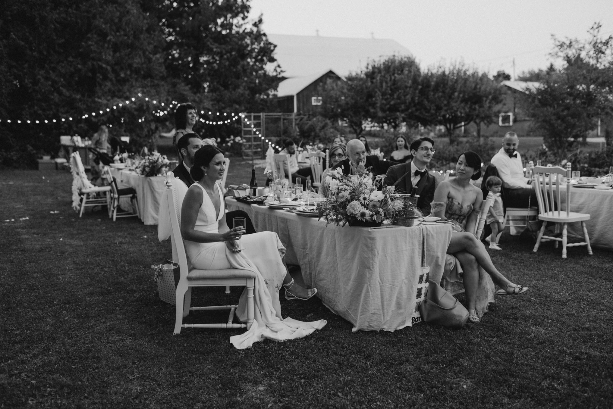 guests listening to speeches at wedding, black and white