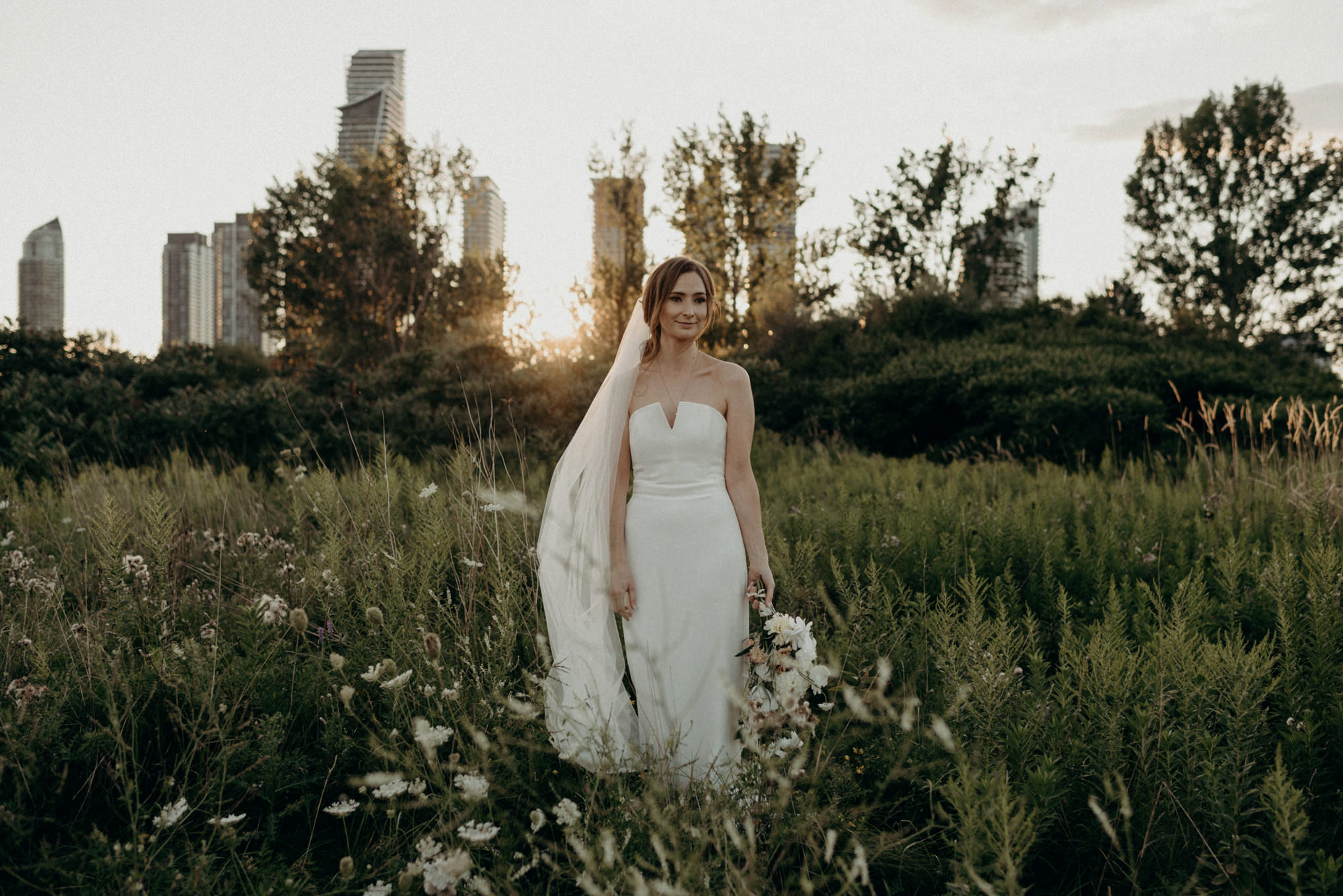 bride with sunset and condo buildings in background at Humber Bay