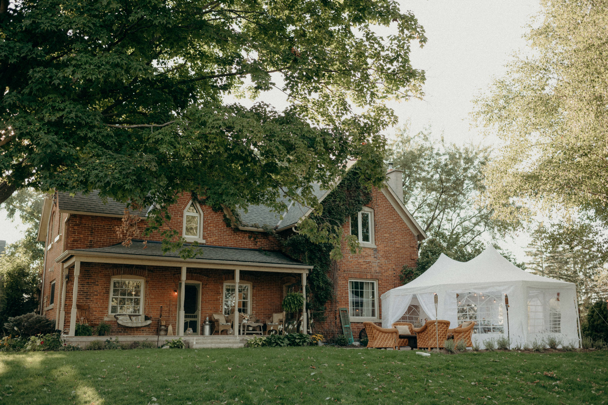 Brick farmhouse with tent set up for wedding reception