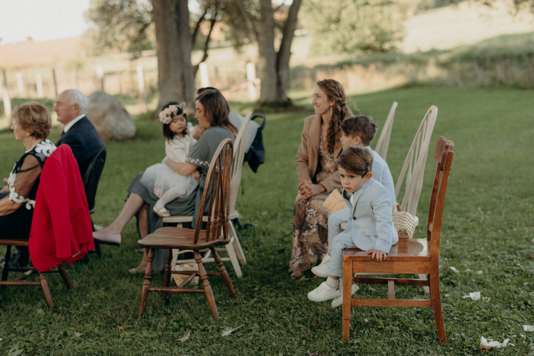 guests on mismatched chairs during outdoor wedding ceremony