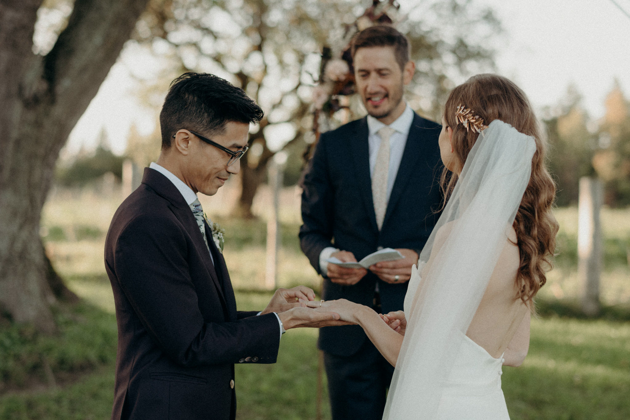 couple exchanging rings during outdoor wedding ceremony