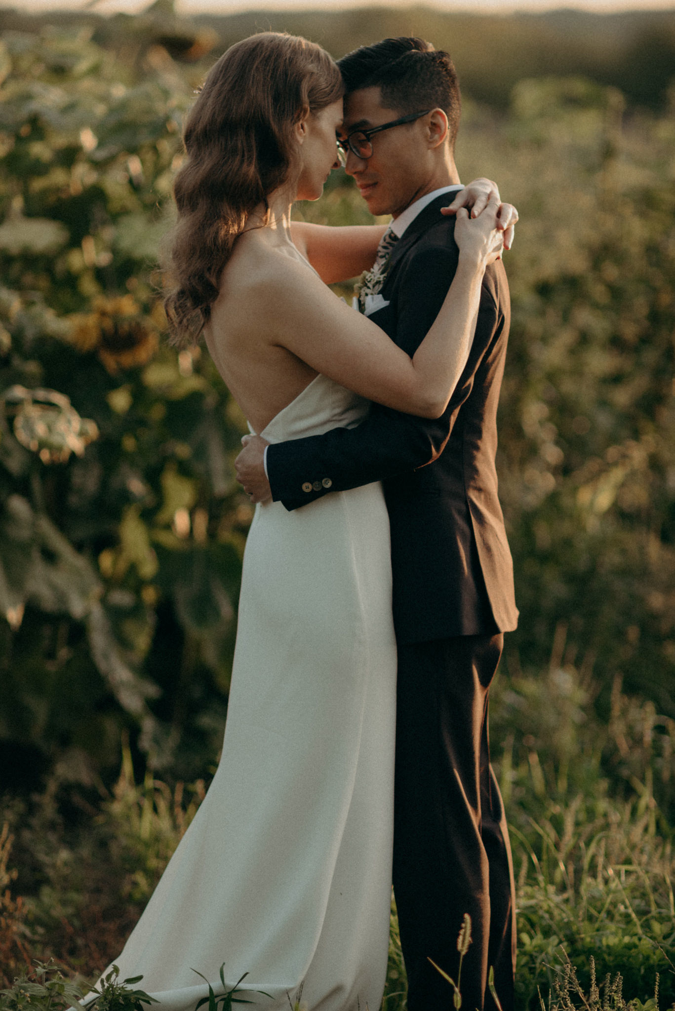 Wedding portraits by sunflowers at sunset