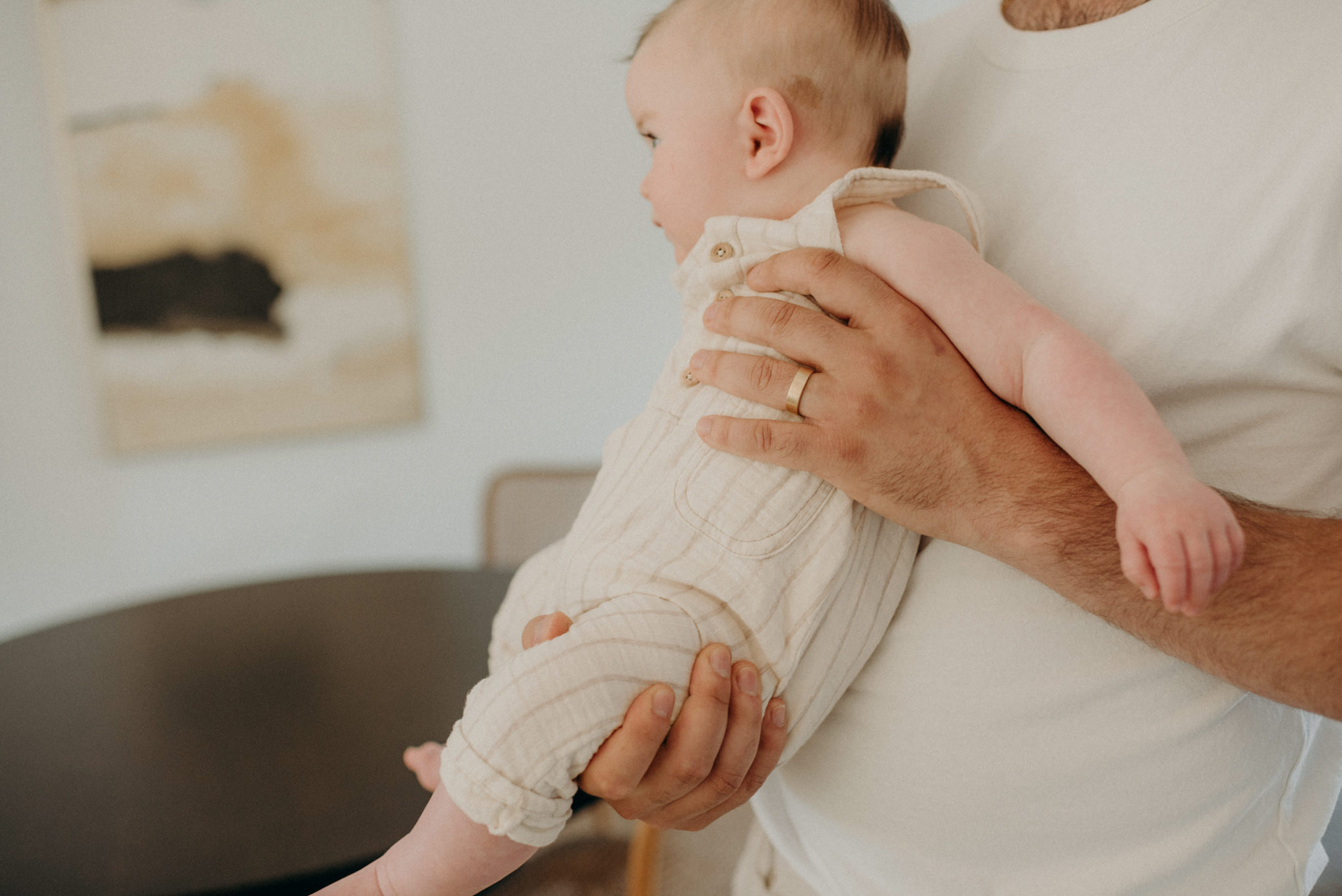 father carrying infant son at home